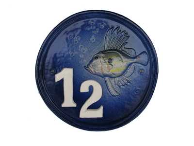 Plaque de maison ronde bleue décorée par un poisson.